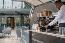 A man is pouring coffee from a coffee cart.