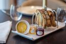 A tray of bread and jam on a table.
