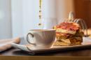 A cup of coffee is being poured onto a plate.