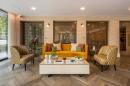 A living room with a yellow couch and a coffee table.