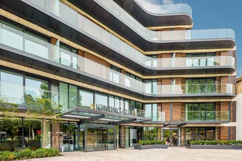 The entrance to a modern building with glass balconies.