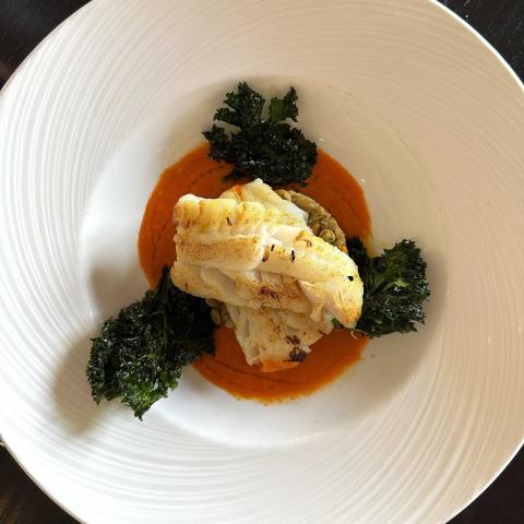 Mediterranean cod served with braised green lentils, a rich red pepper sauce and crispy kale