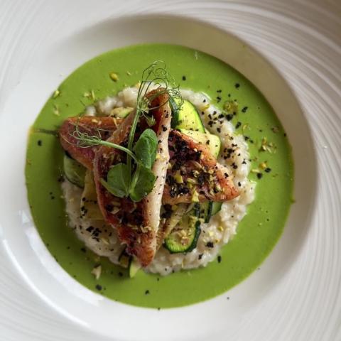 Red mullet with courgette and watercress risotto, topped with pistachio and black olive crumb