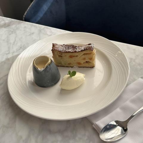 White chocolate and apricot bread and butter pudding served with custard and whipped clotted cream